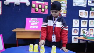 The Kindergarten learners enthusiastically participated in the Magic Countdown Tower Activity, a numeracy-based hands-on learning experience designed to strengthen backward counting and sequencing skills. Paper cups with numbers written at the bottom up to 100 were arranged on the floor, and the children were guided to pick the cups in backward order, starting from 100. With each correct identification, the learners carefully stacked the cups one over the other to build a tall and steady tower, making the activity both exciting and challenging.

Through this engaging activity, the learners practised backward counting up to 100 while improving number recognition and sequencing skills. The task also supported the development of fine motor skills and hand–eye coordination as the children balanced and placed the cups. Additionally, the activity enhanced their concentration, memory, and problem-solving abilities, making learning interactive, meaningful, and enjoyable.

#MagicCountdownTower #BackwardCounting #KGActivities #NumeracySkills #FineMotorSkills #HandsOnLearning #LearningThroughPlay #LittleLearners #MathIsFun #ConcentrationSkills